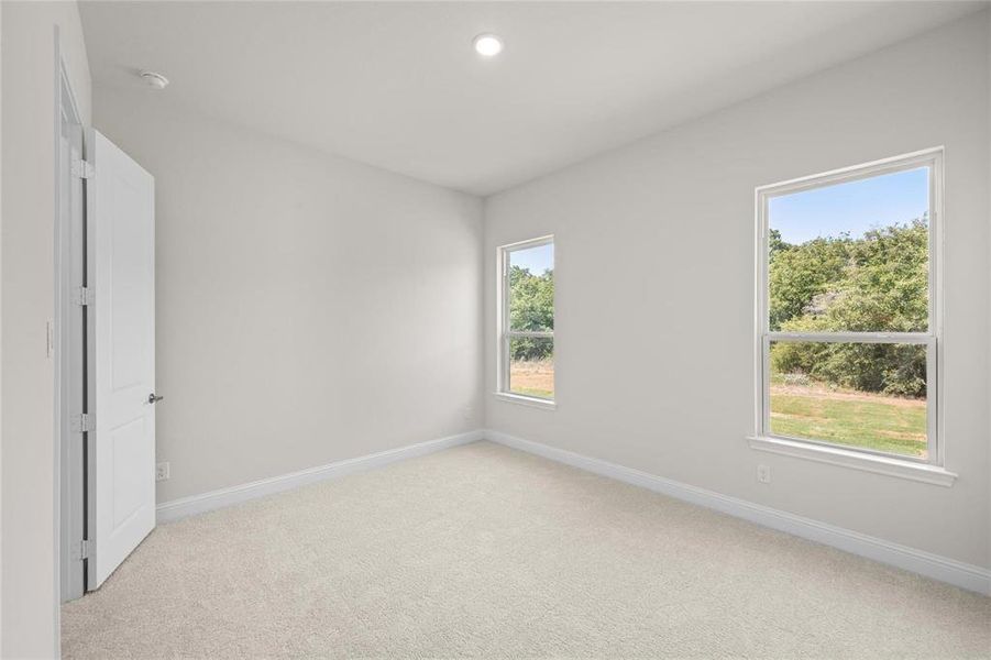 Empty room featuring light colored carpet