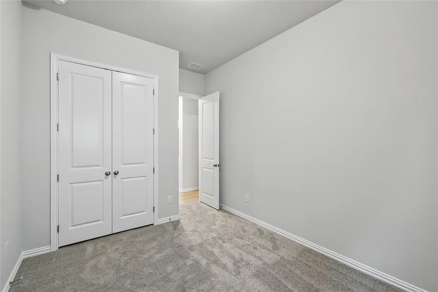 Unfurnished bedroom featuring carpet flooring and a closet Unfurnished bedroom featuring carpet flooring and a closet