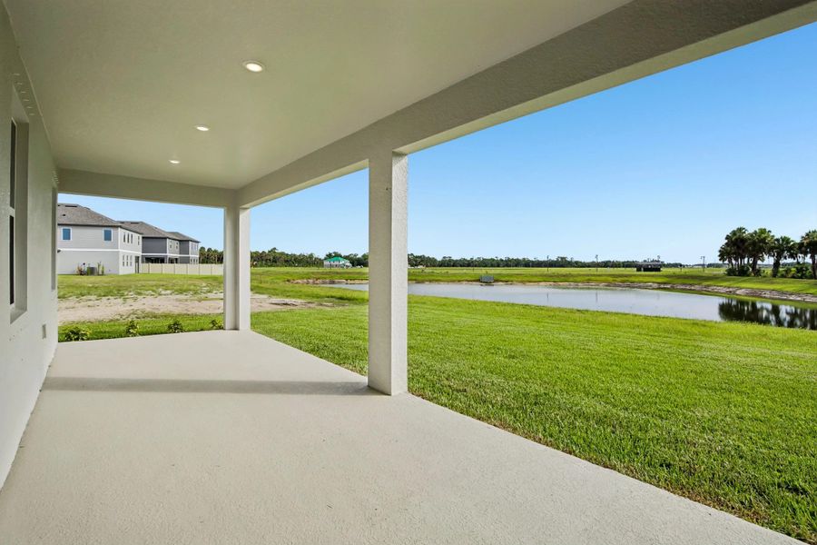 Stunning covered back lanai features views of the backyard pond