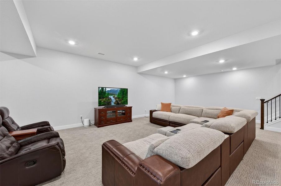 Basement Media Area (Angle 2) – Open-concept layout accommodates both lounging and recreation, with soft lighting and a seamless connection to the wet bar area.