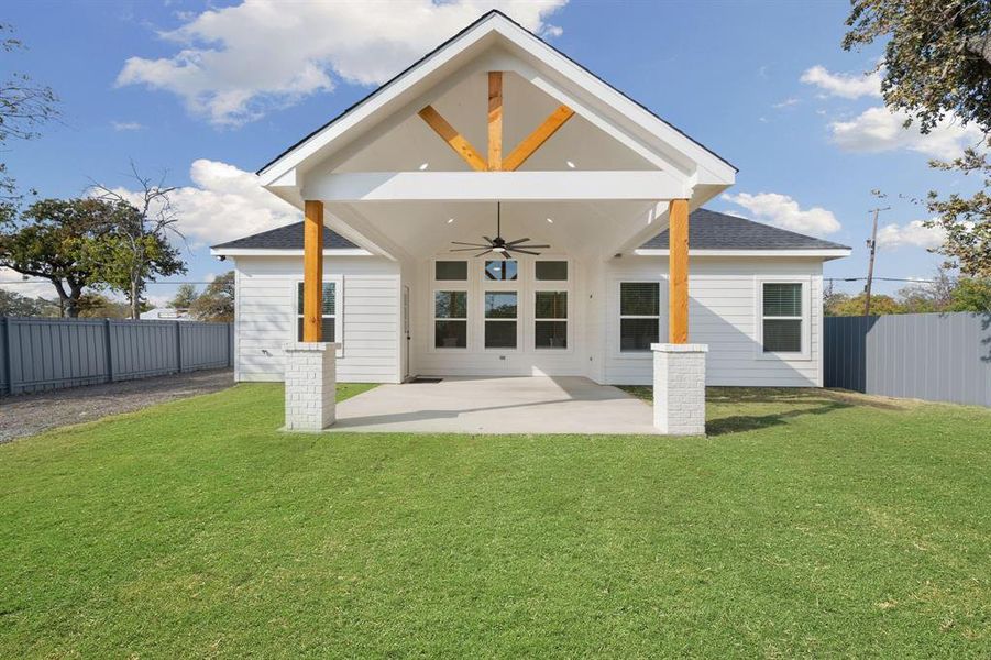 Rear view of property featuring ceiling fan, a fenced backyard, a patio area, and a shingled roof