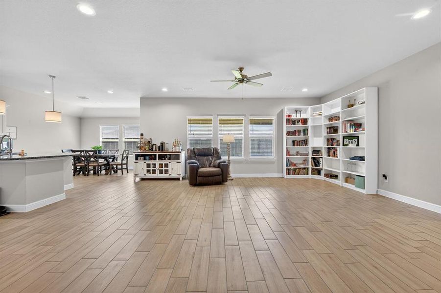 Open-concept living area featuring wood-finish flooring, recessed lighting, and a ceiling fan