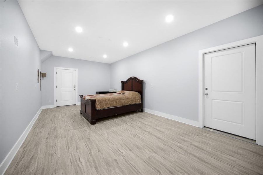 Bedroom with light wood-type flooring and recessed lighting