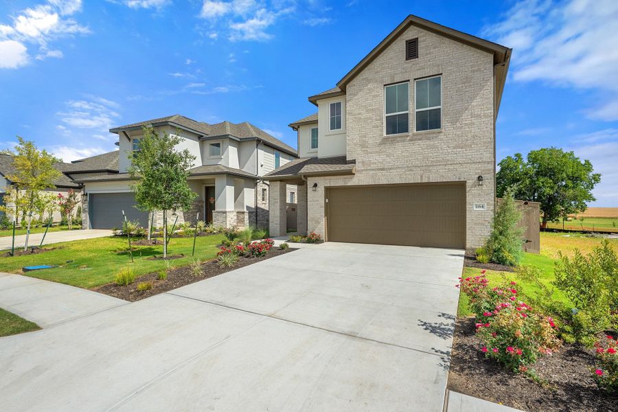Front exterior of a new home in Flora, Hutto, TX, highlighting curb appeal (Image 2). Front exterior of a new home in Flora, Hutto, TX, highlighting curb appeal (Image 2).