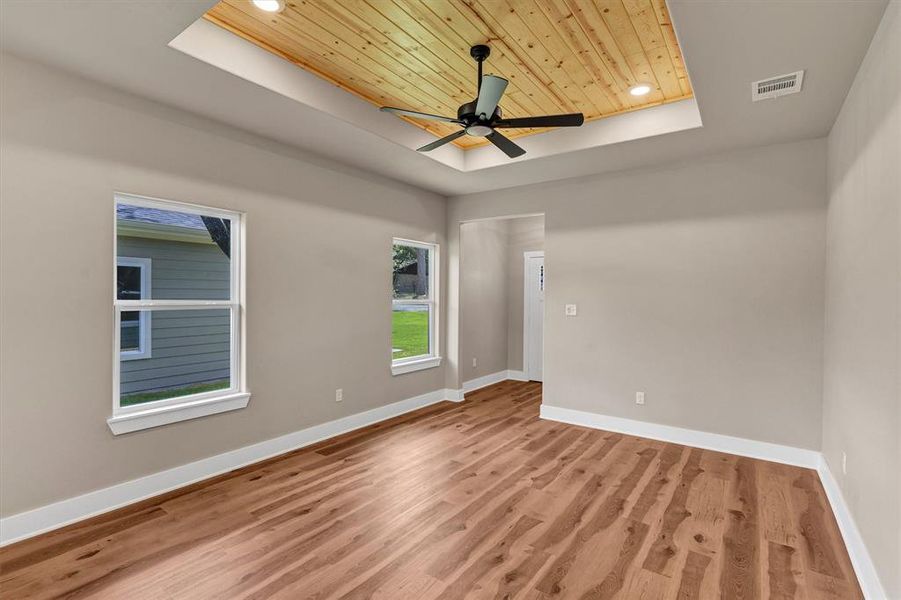Unfurnished room featuring a raised ceiling, wood ceiling, recessed lighting, light wood-style floors, and ceiling fan Unfurnished room featuring a raised ceiling, wood ceiling, recessed lighting, light wood-style floors, and ceiling fan