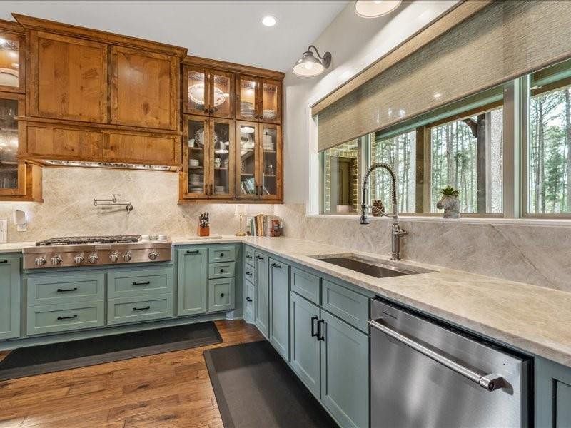 Vintage Rustic style design in the kitchen with top of the line stainless appliances and large sink.  Views of the pine trees makes washing dishes relaxing.  Top of the line quartzite counters and backsplash.
