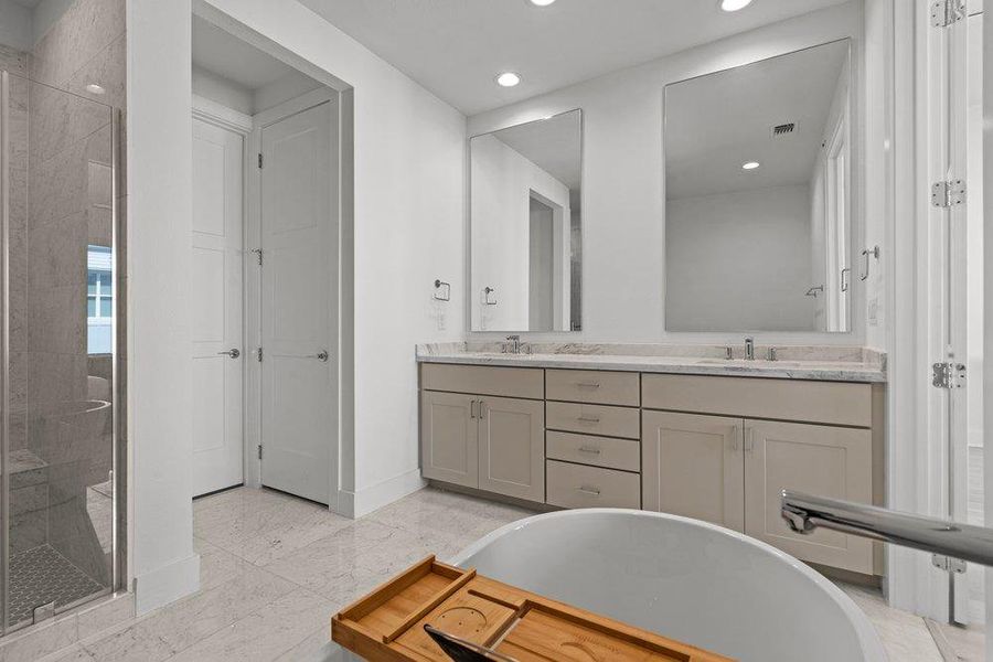 Fine stone surfaces and a soaking tub elevate this light-filled modern bath design. Fine stone surfaces and a soaking tub elevate this light-filled modern bath design.