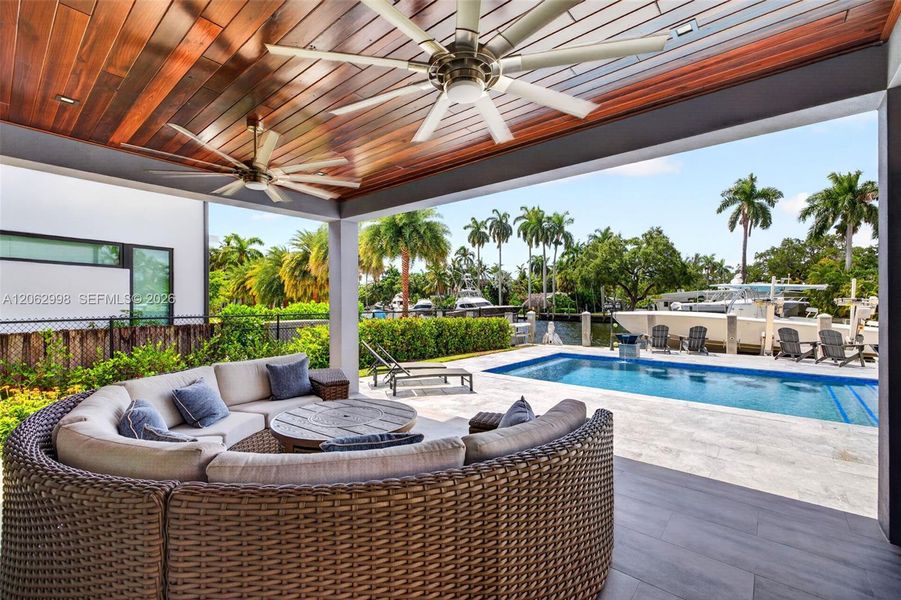 Covered patio w/ T&G ceilings, fans, fire pit seating and outdoor kitchen overlooks the gorgeous wide New River views and pool area