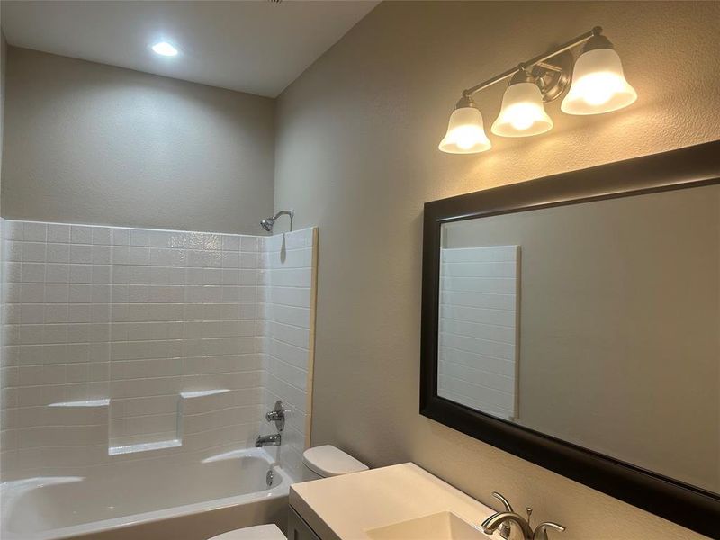 Bathroom with toilet, shower / bathtub combination, and vanity