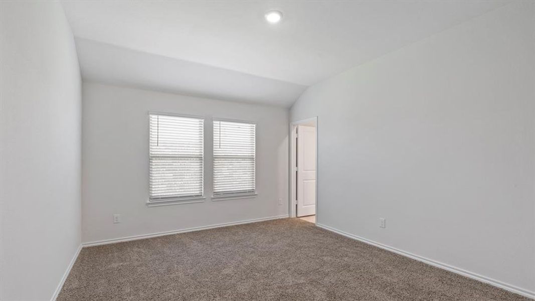 Room featuring light gray carpet, white walls, two windows with blinds, a vaulted ceiling, and a recessed light fixture