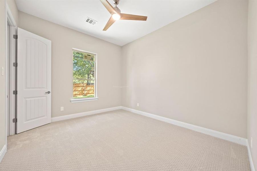 Carpeted empty room with ceiling fan