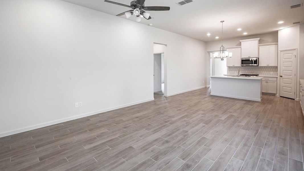Unfurnished living room featuring a chandelier, light wood finished floors, recessed lighting, and a ceiling fan
