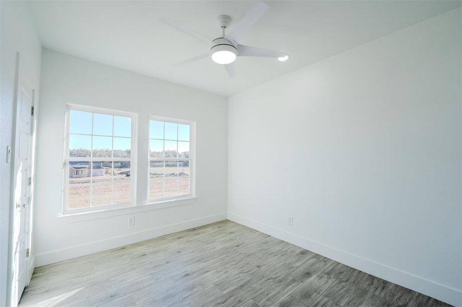 Bedroom (1) with light wood finished floors, ceiling fan, and recessed lighting Bedroom (1) with light wood finished floors, ceiling fan, and recessed lighting