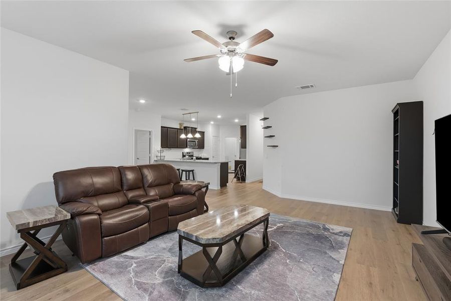 Living space featuring wood-finish flooring, recessed lighting, and a ceiling fan with light fixture