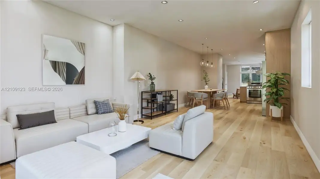 Open-concept interior featuring wood-finish flooring, recessed lighting, and wood-paneled cabinetry Open-concept interior featuring wood-finish flooring, recessed lighting, and wood-paneled cabinetry