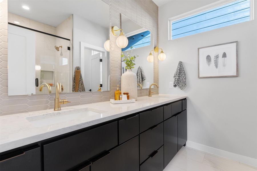 Bathroom with double vanity, a stall shower, and backsplash