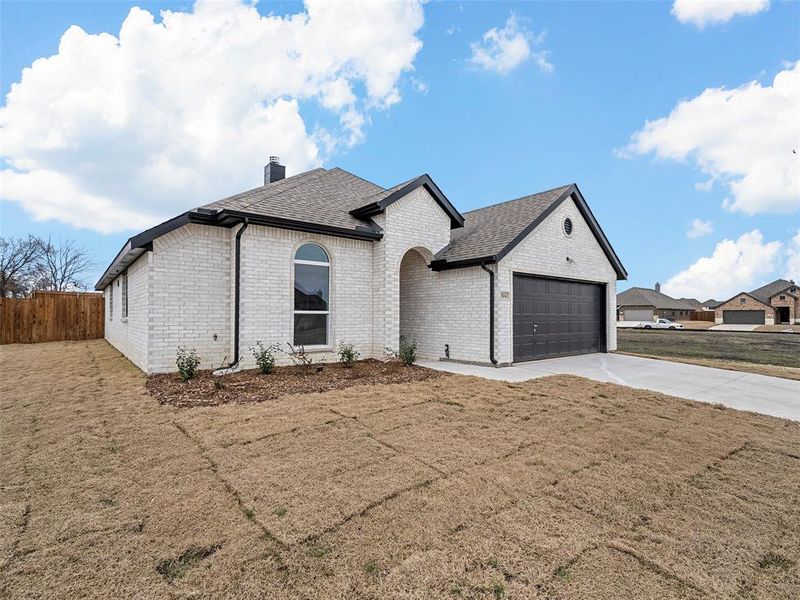 French provincial home with fence, roof with shingles, a chimney, driveway, and an attached garage