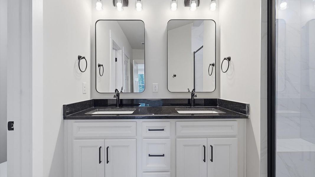 Highly functional and elegant en-suite with dual vanities, tiled walk-in shower, and refined finishes