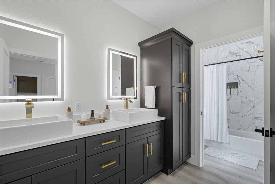 Full bathroom with shower / bath combo with shower curtain, double vanity, and light wood finished floors
