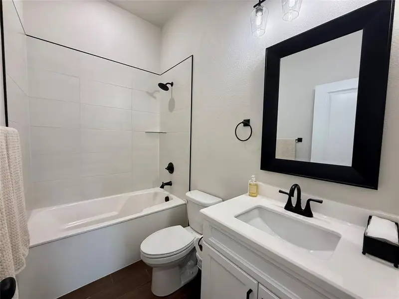 Bathroom with shower / bath combo, vanity, and wood tiled floors Bathroom with shower / bath combo, vanity, and wood tiled floors