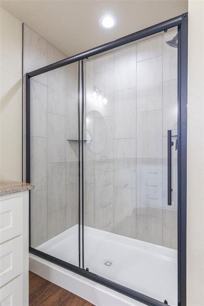 Shower enclosure with a matte black frame, clear glass panels, and a white shower pan