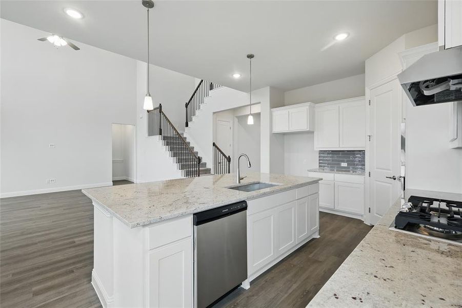 Kitchen featuring a sink, tasteful backsplash, appliances with stainless steel finishes, dark wood-style floors, and under cabinet range hood