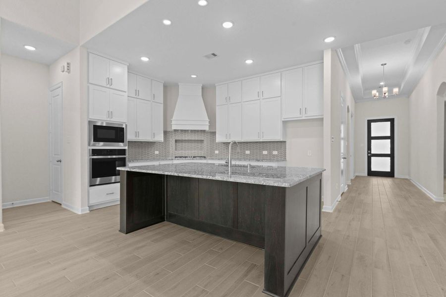 Large central island offering breakfast bar seating and plenty of prep space, perfect for casual dining or hosting gatherings.