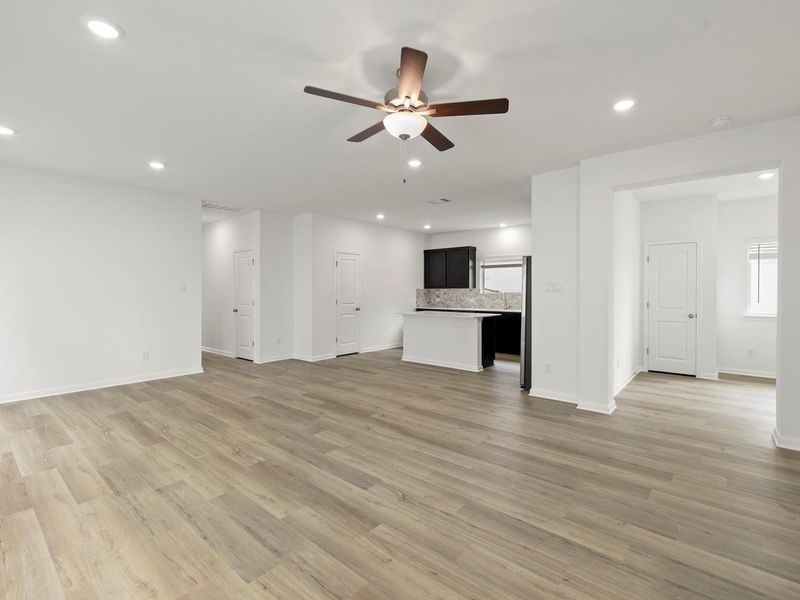 An open floorplan seamlessly connects the well-lit living area to a compact kitchen, perfect for modern living.