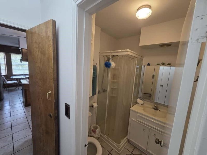 Full bath with light tile patterned floors, vanity, and a stall shower Full bath with light tile patterned floors, vanity, and a stall shower