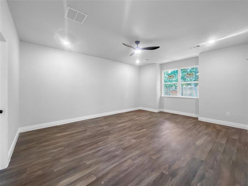 Unfurnished room with dark wood-style flooring and a ceiling fan Unfurnished room with dark wood-style flooring and a ceiling fan