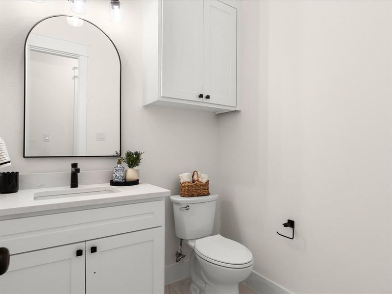 Bathroom featuring a white vanity with panel cabinetry, a rectangular undermount sink, and a black single-handle faucet