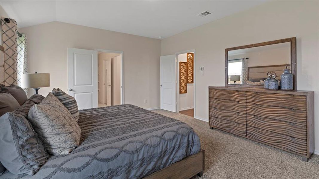 Carpeted bedroom featuring lofted ceiling and baseboards