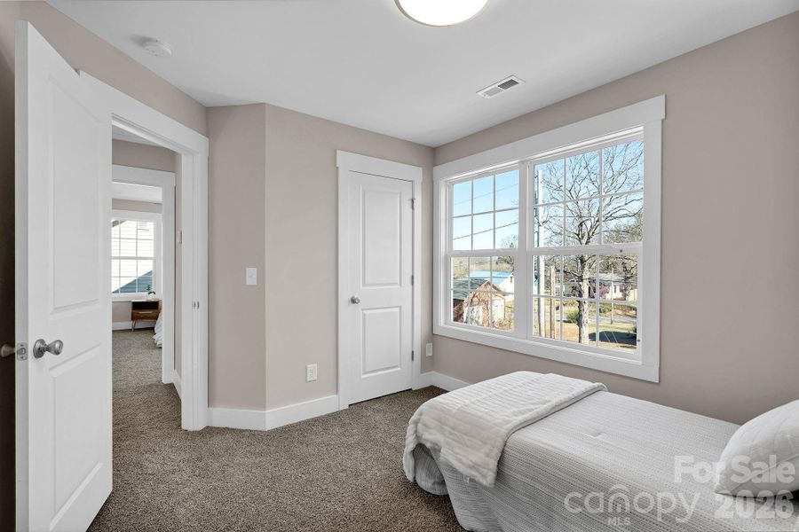 Another upstairs bedroom with a comfortable layout and oversized windows.