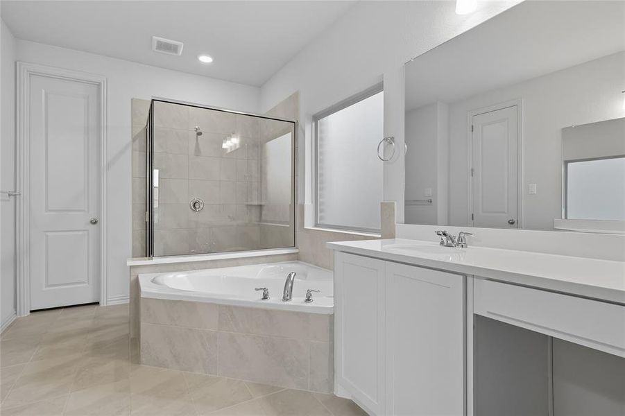 Full bathroom with a garden tub, vanity, a shower stall, light tile patterned floors, and recessed lighting Full bathroom with a garden tub, vanity, a shower stall, light tile patterned floors, and recessed lighting