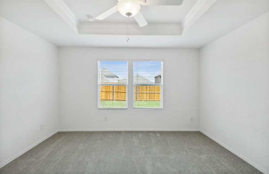 Elegant owner's suite with tray ceiling *real home pictured