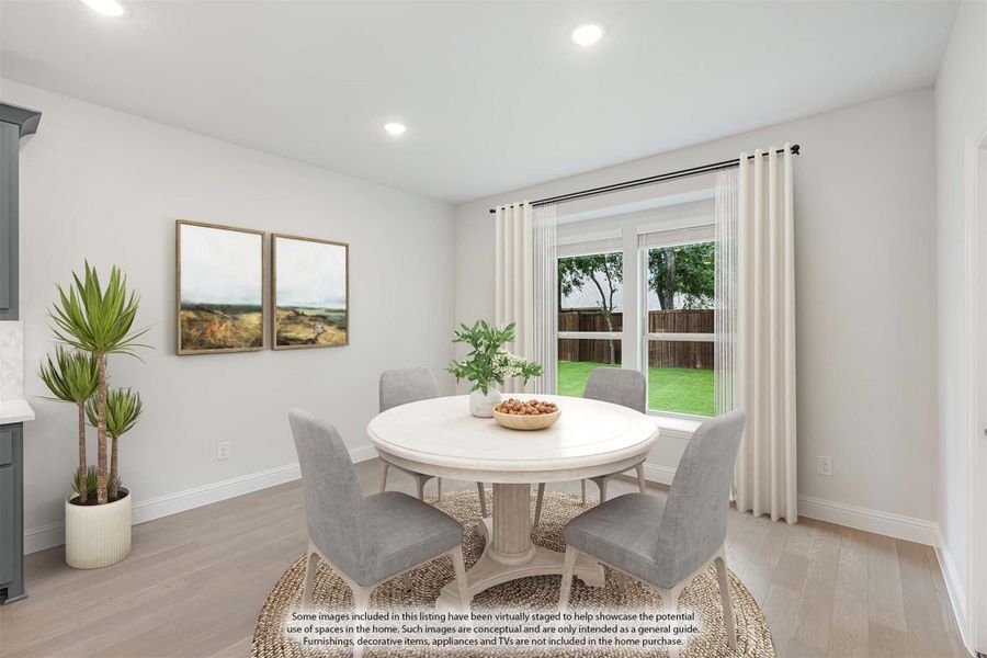 Dining area with round white table, four gray chairs, and large window overlooking backyard Dining area with round white table, four gray chairs, and large window overlooking backyard