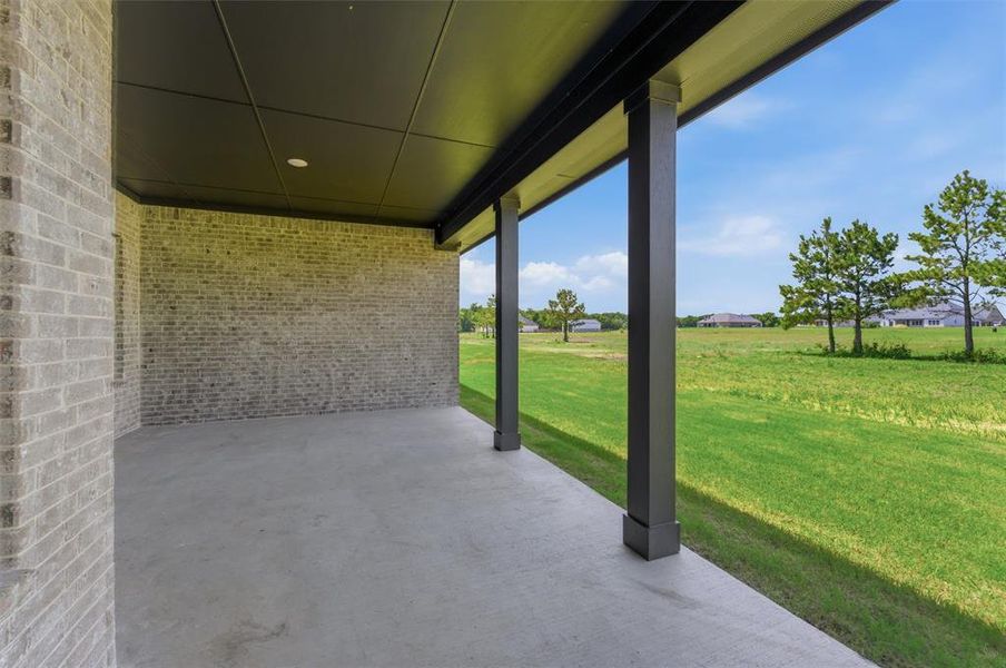 Covered patio featuring a concrete slab, brick exterior wall, and dark ceiling with recessed lighting Covered patio featuring a concrete slab, brick exterior wall, and dark ceiling with recessed lighting