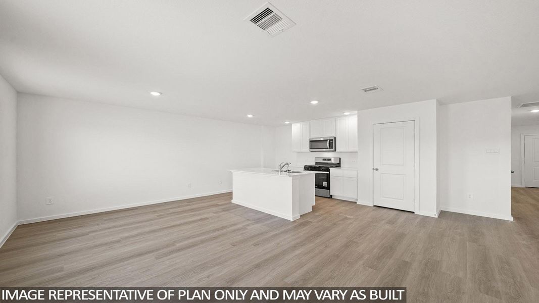 An open concept living area features resilient plank flooring and a sleek kitchen with an island. An open concept living area features resilient plank flooring and a sleek kitchen with an island.