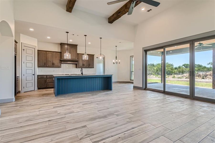 Unfurnished dining area featuring crown molding, light wood-type flooring, and ceiling fan with notable chandelier