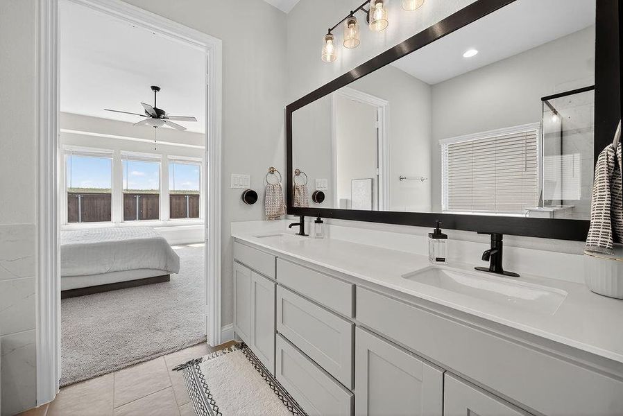 Dual vanity with white shaker cabinetry, white countertops, and matte black fixtures