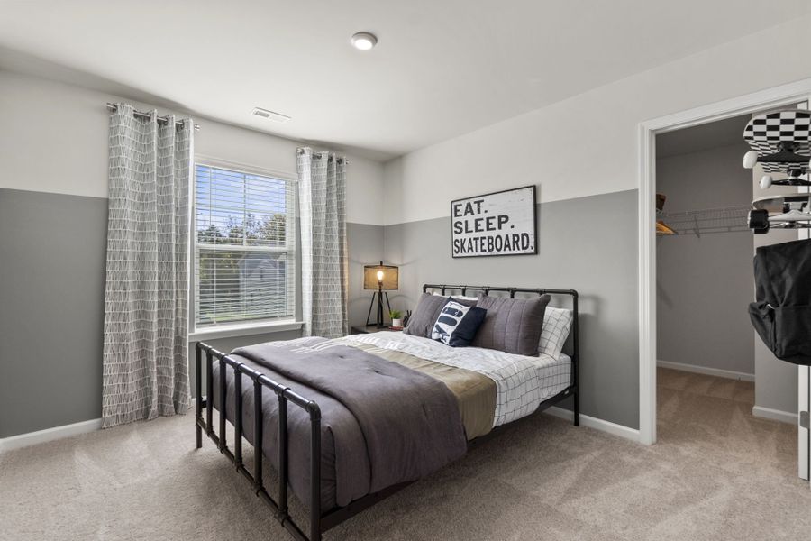 A bedroom with a bed and a lamp.