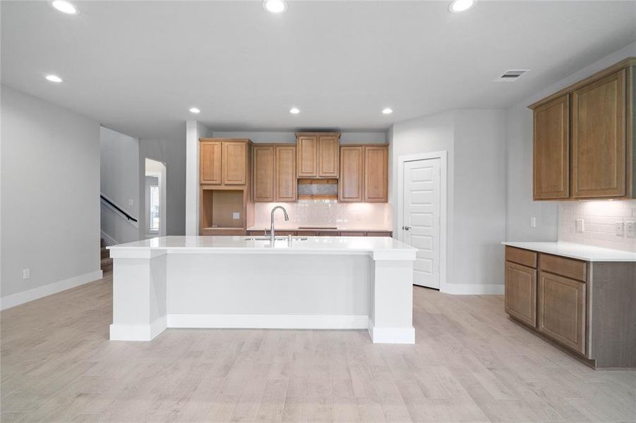 This kitchen is by far any chef’s dream! This spacious kitchen features high ceilings, stained wood cabinets, quartz countertops, SS appliances, modern tile backsplash, recessed lighting, quartz kitchen island with space for breakfast bar and extra storage, and a walk-in pantry all overlooking your huge family room.