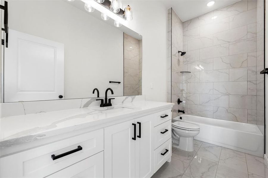 Full bathroom featuring vanity, light marble finish floors, and shower / tub combination