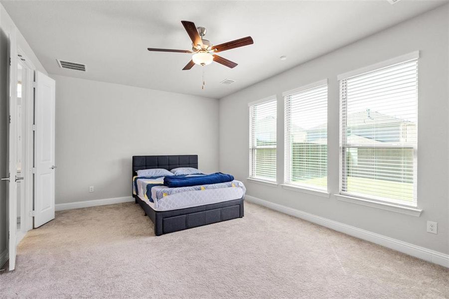 Carpeted bedroom featuring ceiling fan