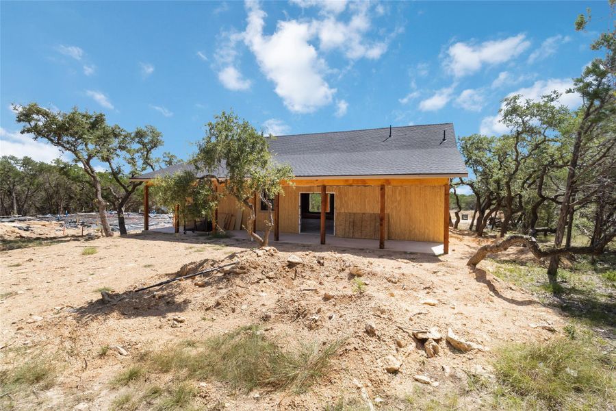 Back of house featuring a patio area and a shingled roof Back of house featuring a patio area and a shingled roof