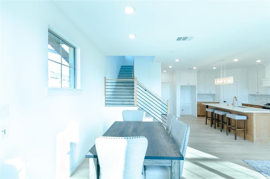 Dining area featuring stairway, light wood-style floors, and recessed lighting