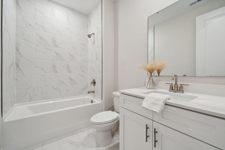 A bathroom with a tub sink and toilet.