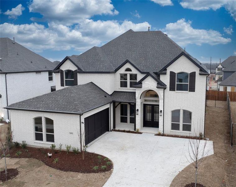 French provincial home with a garage and french doors