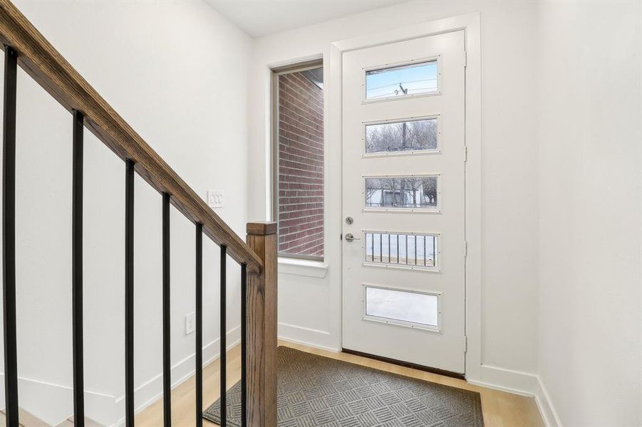 Entrance foyer featuring light wood-style floors, stairs, and baseboards