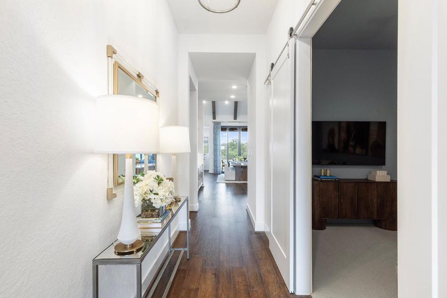 Hallway with baseboards, a barn door, and dark wood-style floors Hallway with baseboards, a barn door, and dark wood-style floors